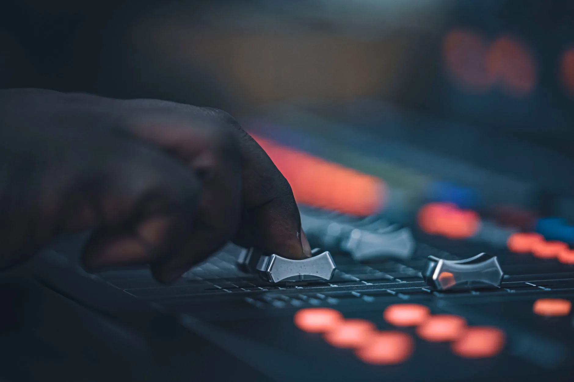 Sound engineer in control room, headphones on, hand near mixer. Sound memes.