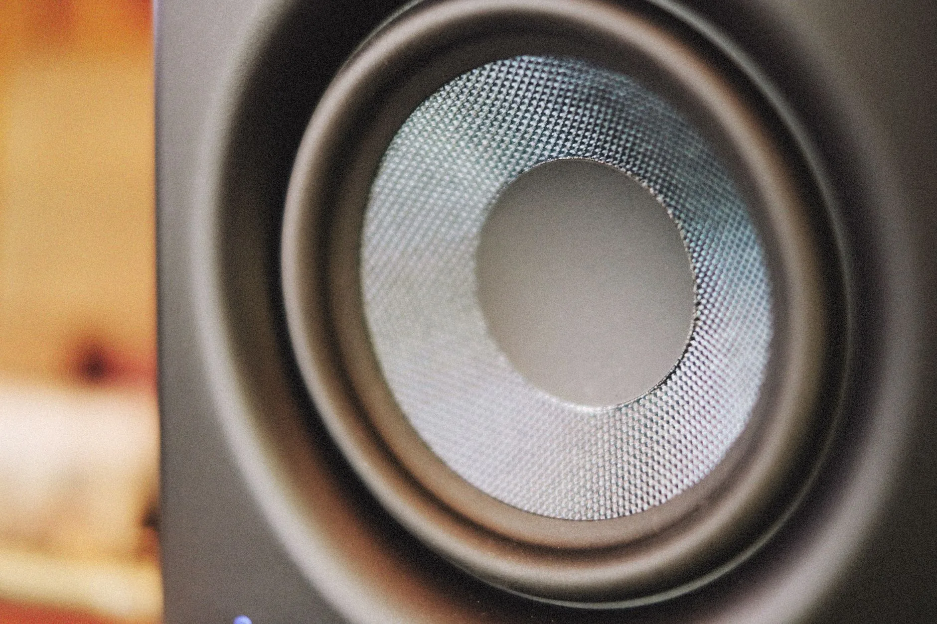 Modern white noise machine on dark wooden desk, muted colors, soft lighting.